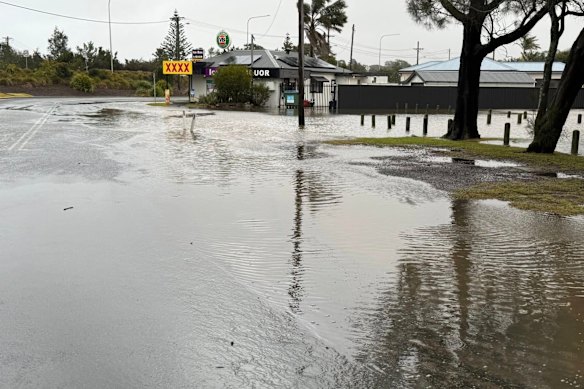 Floodwater surrounds a bottle shop in Burrill Lake.