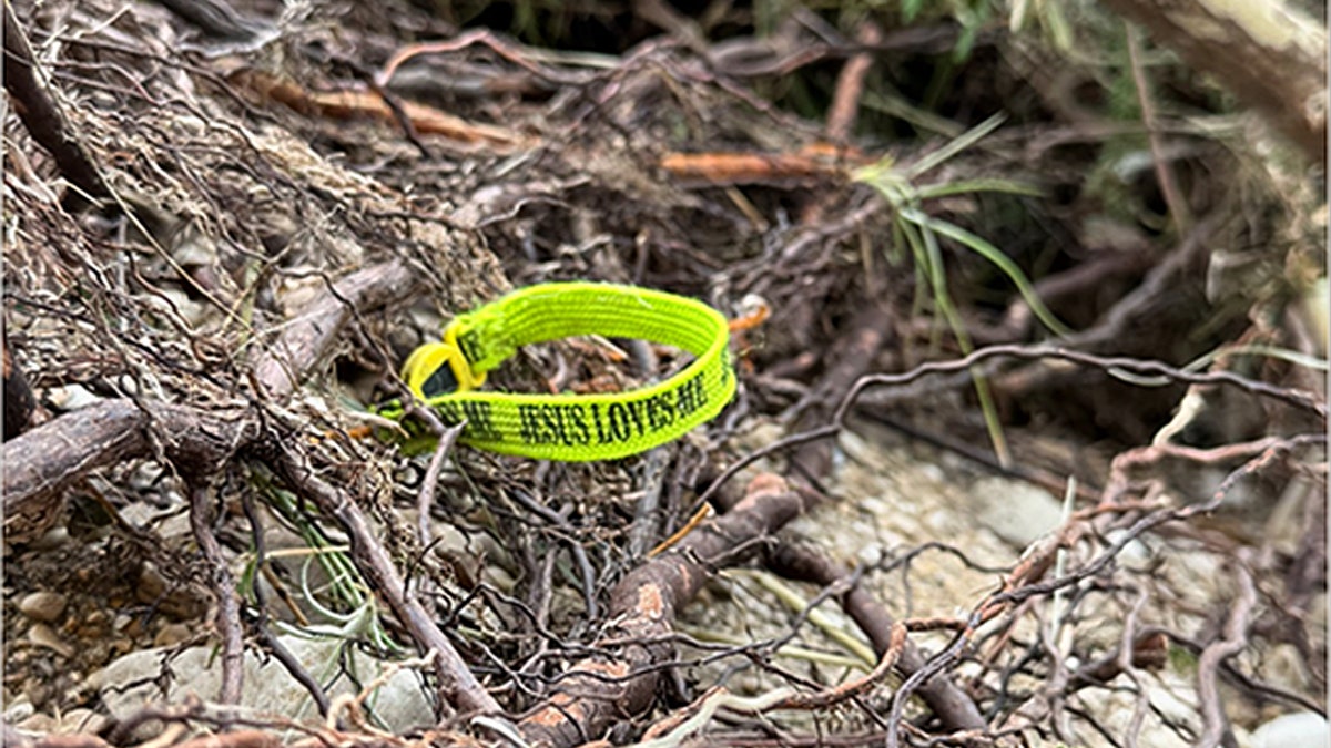 A neon colored bracelet reading "Jesus loves me" was found after the flood in Kerrville, Texas.