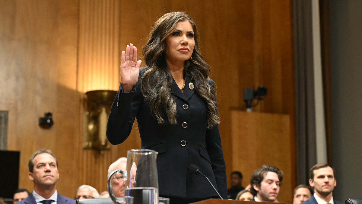 Kristi Noem with her hand raised