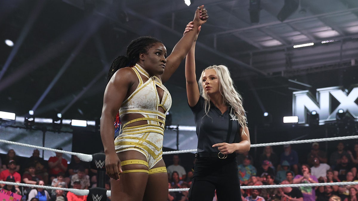 Vicky D'Errico raises the hand of Tyra Mae Steele