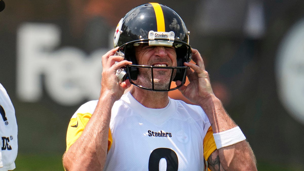 Aaron Rodgers puts his helmet on