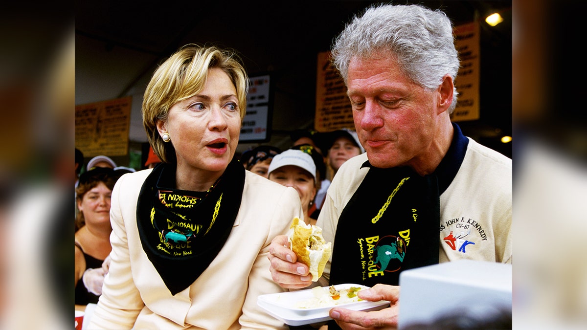 Hillary Clinton looks at then-President Bill Clinton eating a sandwich