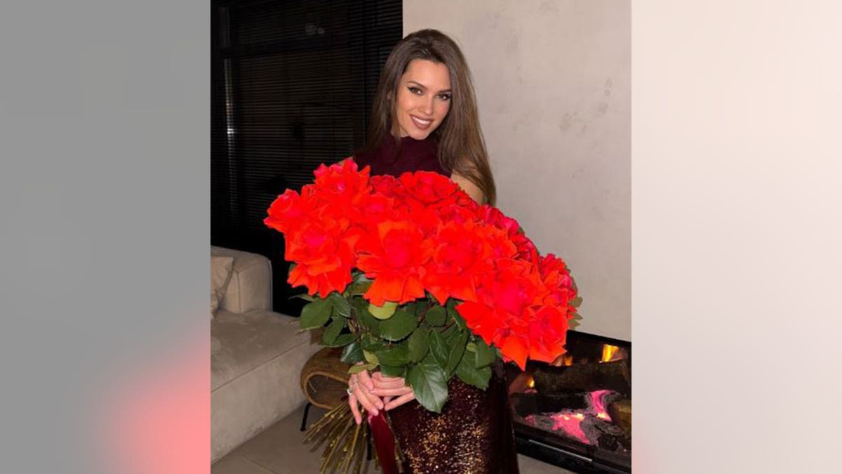 Kseniya Alexandrova posing with red flowers
