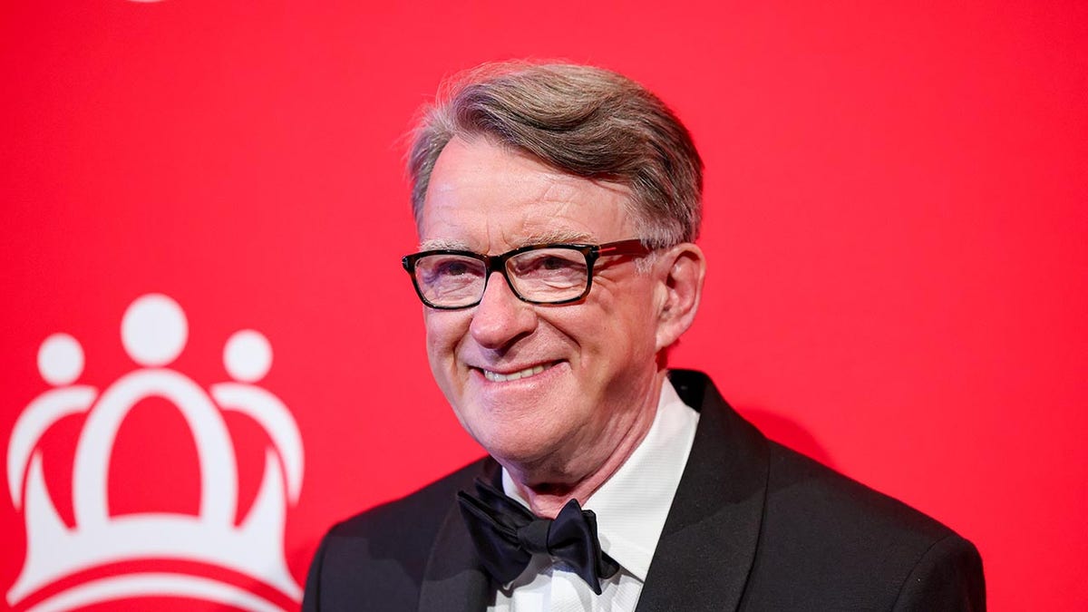 Peter Mandelson smiles on red carpet