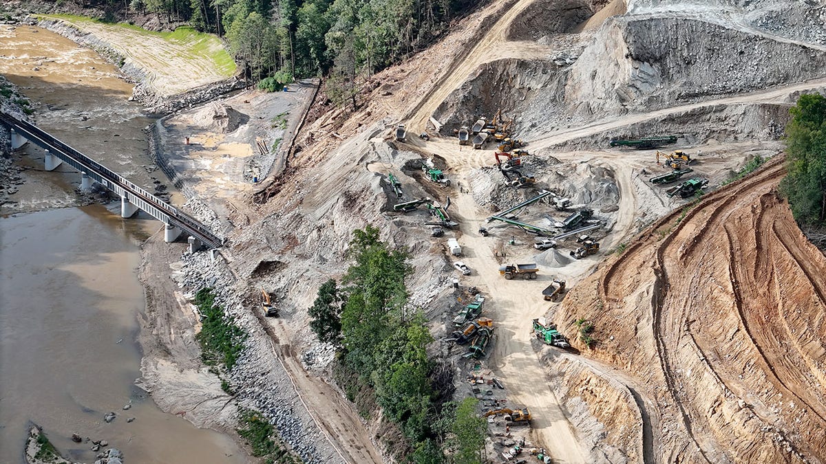 Dirt roads and heavy duty vehicles are seen in a forest at the site of a North Carolina mining operation.