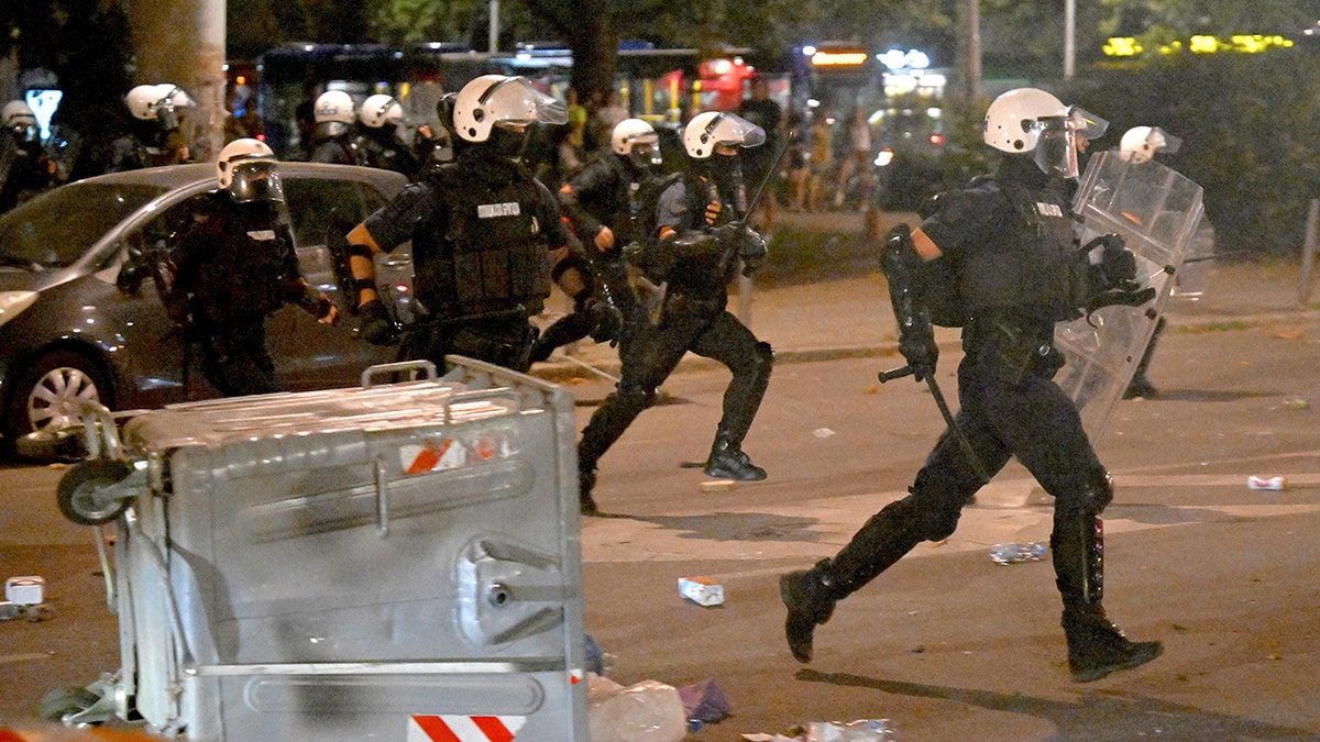 Serbian riot police clash with anti-government protesters in Belgrade on August 13.