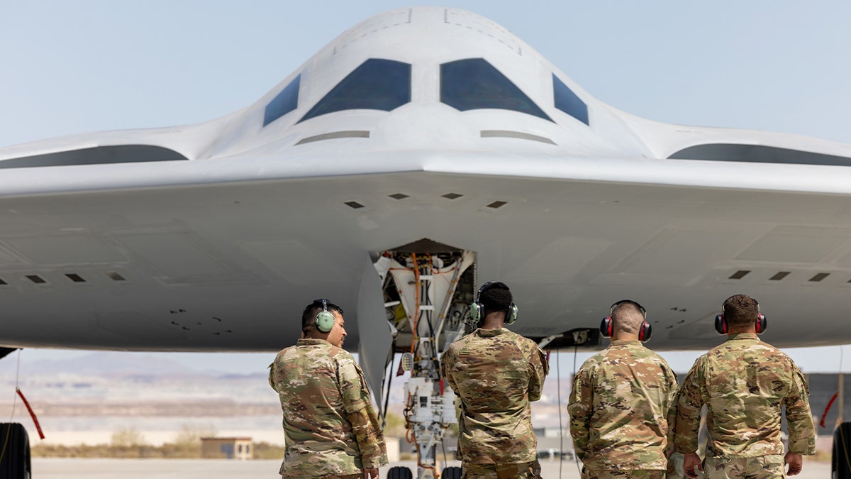 Head-on shot of B-21 with airmen facing toward the jet.
