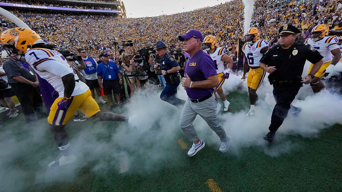 Brian Kelly runs onto the field