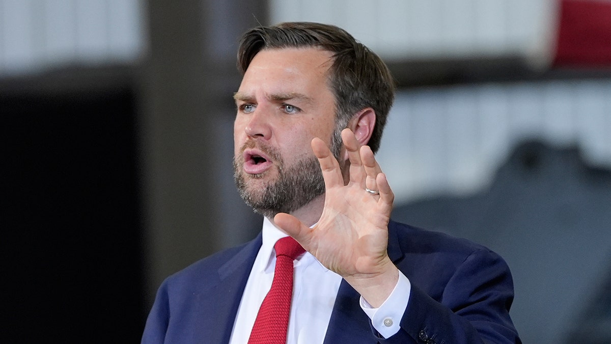 Vice President JD Vance in dark suit and red tie speaking