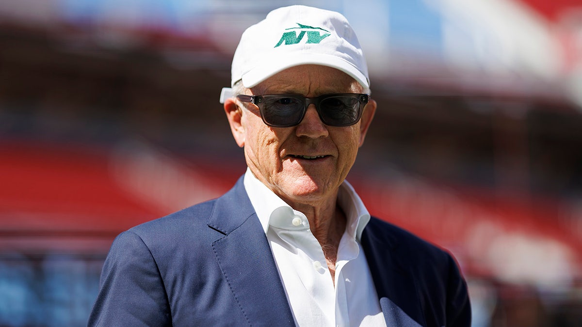 Woody Johnson walks on the field