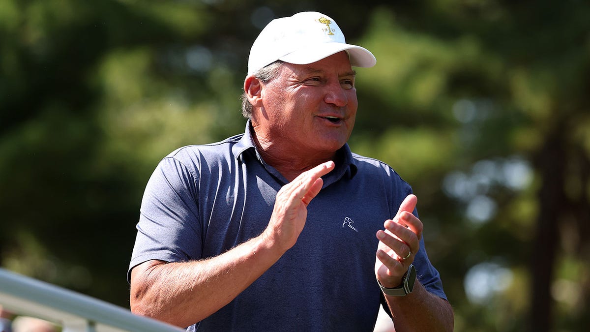 Ed Orgeron watches a golf tournament