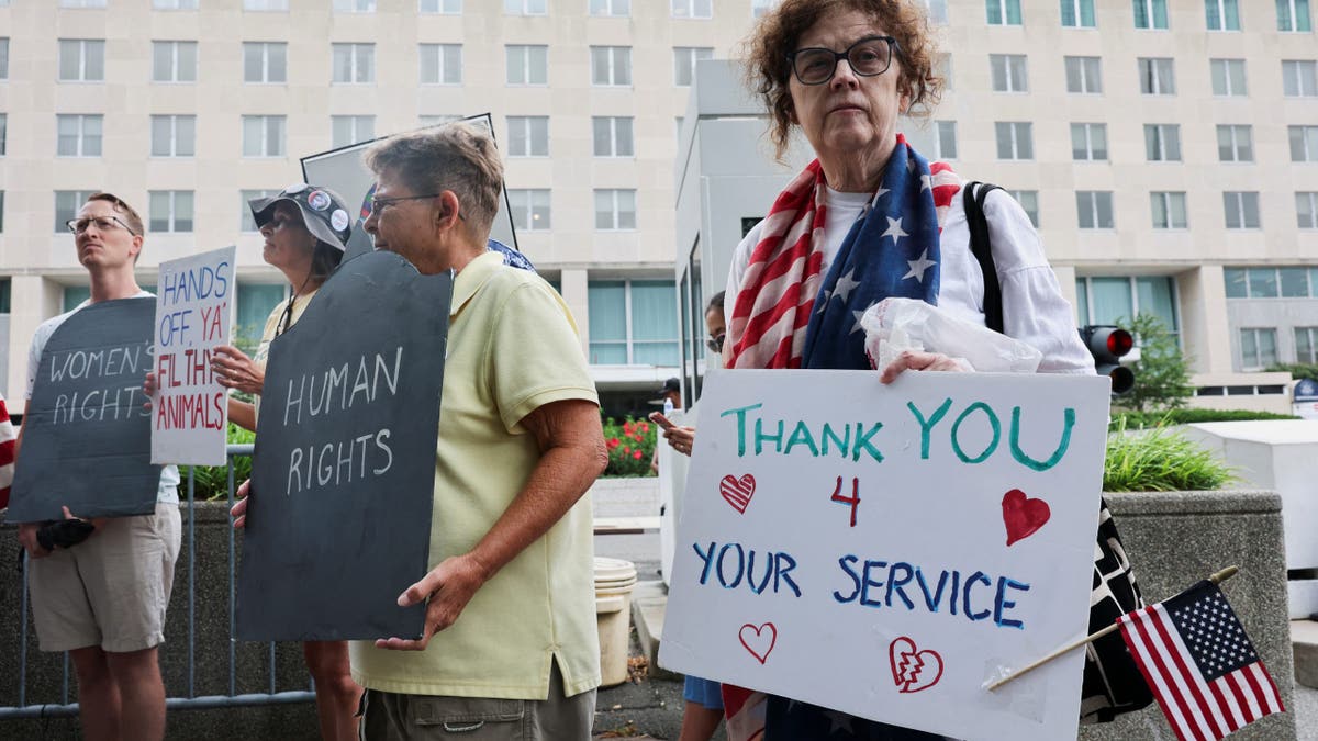 A group of people protest a reduction in force affecting workers at the State Department.