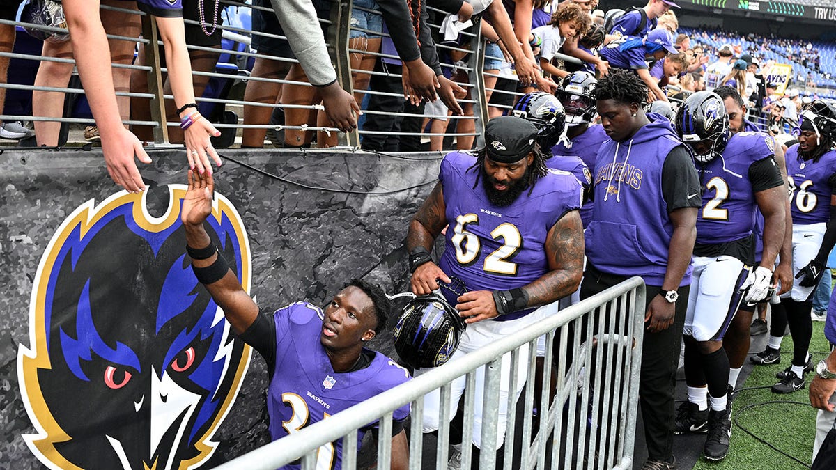 Baltimore Ravens players walk toward the locker room
