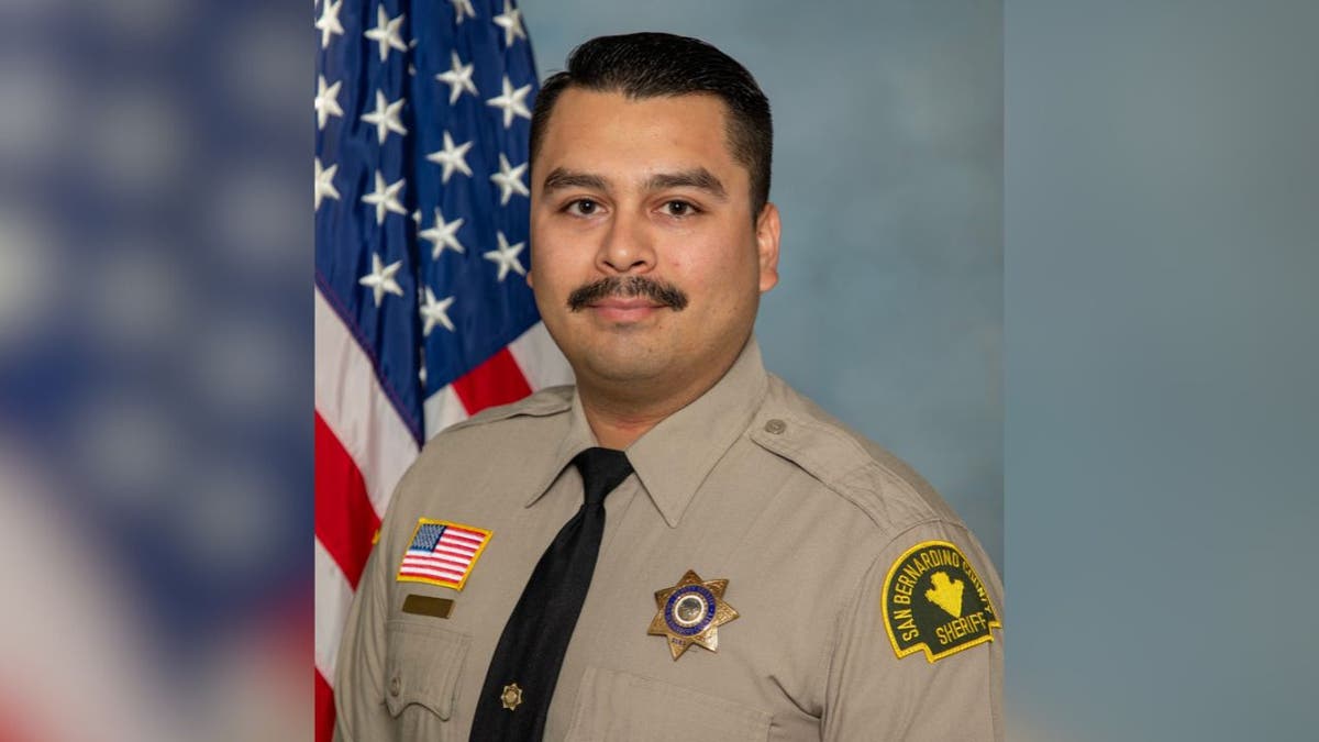 Portrait of Deputy Andrew Nunez in uniform with the U.S. flag behind him.