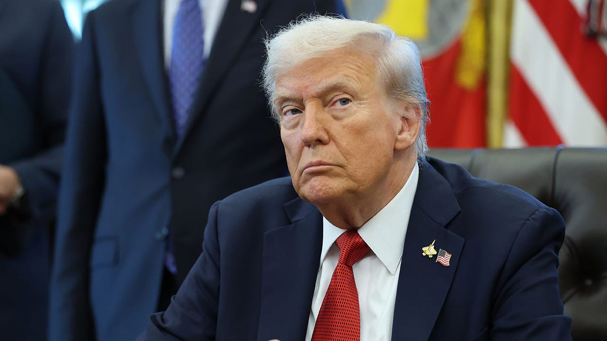 President Donald Trump sitting at his desk in the Oval Office