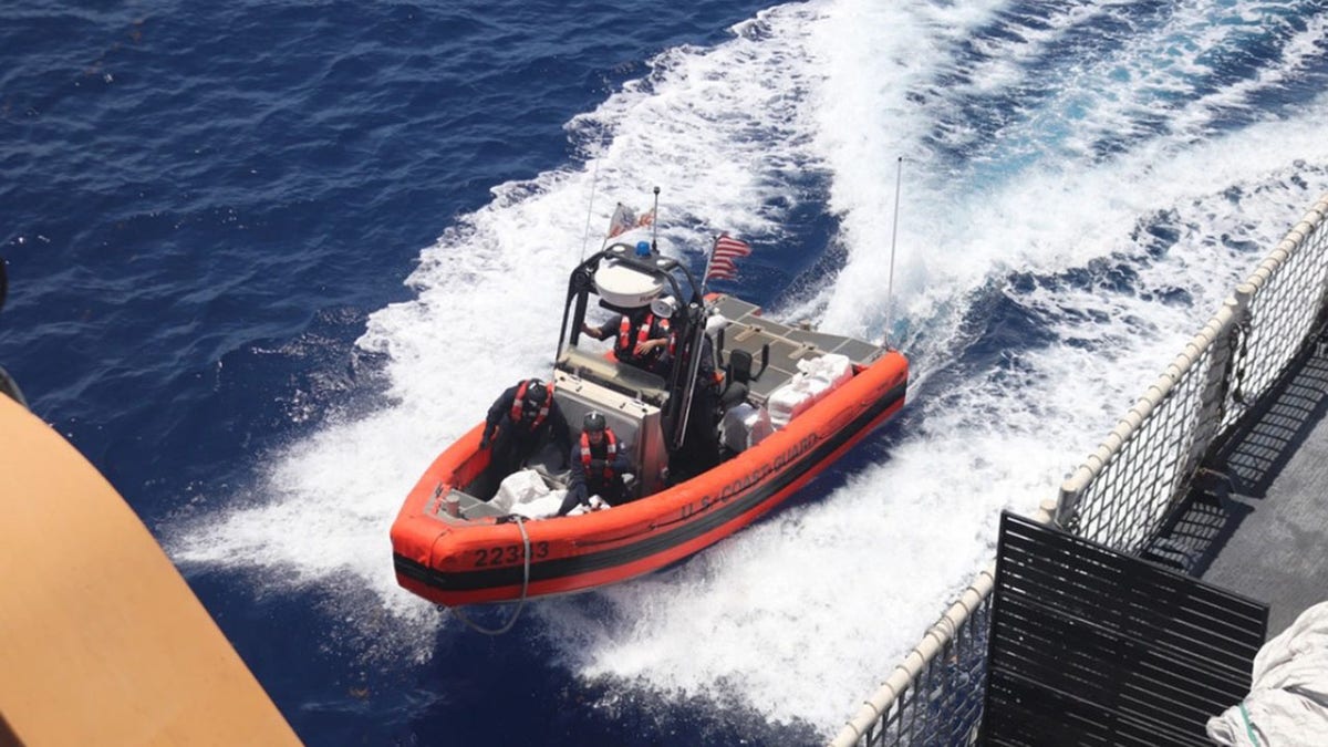 A Coast Guard boat with illegal drugs near a large ship.