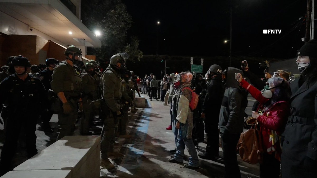 Federal troops and protests standing along a line during a clash