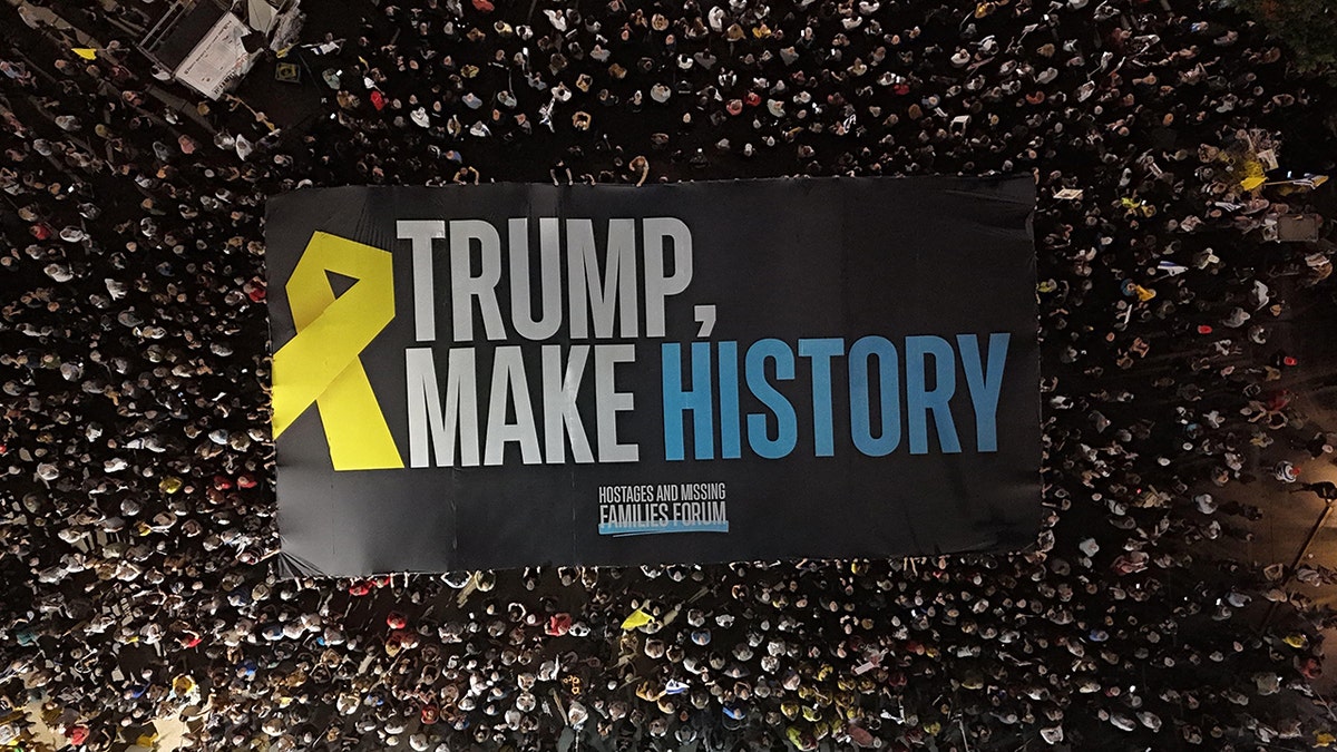 Protesters display a flag calling on President Trump to “Make History” at a rally in Tel Aviv on Aug. 30 pressing for the release of hostages from Gaza. 