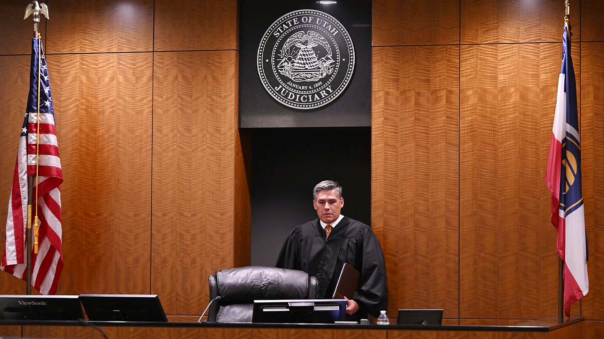Judge Tony Graf carries a folder into his courtroom for a hearing for Tyler Robinson