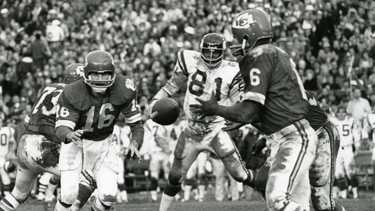 Warren McVea takes the ball from Len Dawson