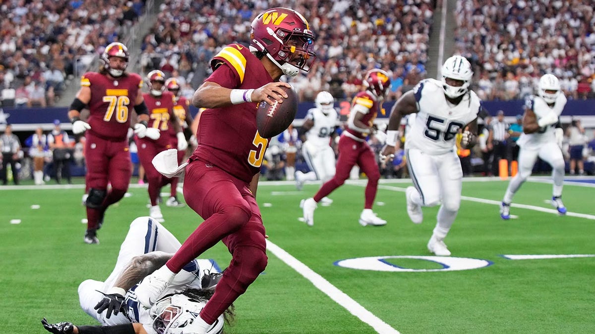 Jayden Daniels gets out of a tackle