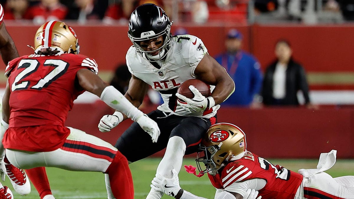 Bijan Robinson tries to avoid the defense