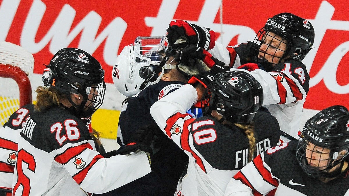Emily Clark, #26, Sarah Fillier, #10, and Renata Fast, #14 of Canada, fight Megan Keller, #5 of the United States, in the 2021 IIHF Women's World Championship Group A match played at WinSport Arena on August 26, 2021 in Calgary, Canada.