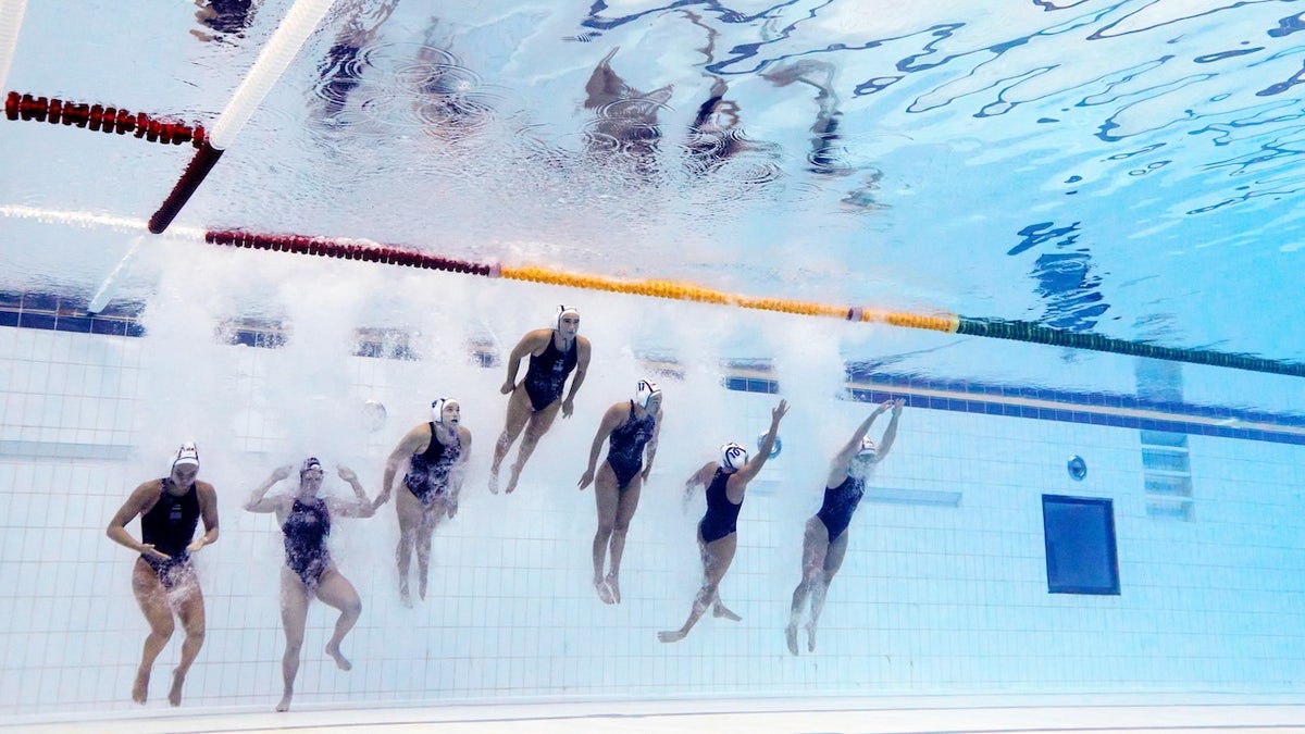 Members of Team United States jump into the pool prior to the Women's Water Polo Quarterfinal match between the United States and Japan on day nine of the Singapore 2025 World Aquatics Championships at OCBC Aquatic Centre on July 19, 2025, in Singapore. 