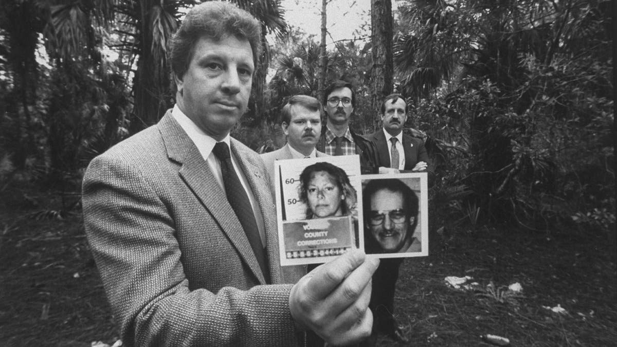 Investigators holding a photo of Aileen Wuornos and one of her victims.
