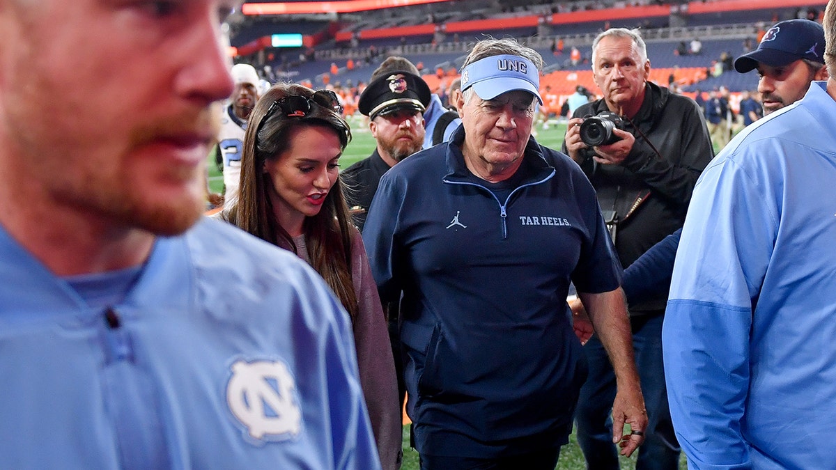 Bill Belichick and Jordon Hudson walk