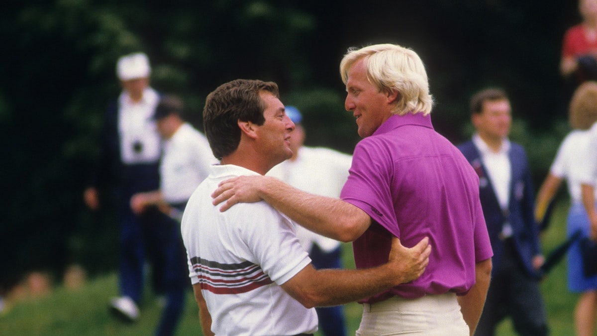 Fuzzy Zoeller and Greg Norman embracing.