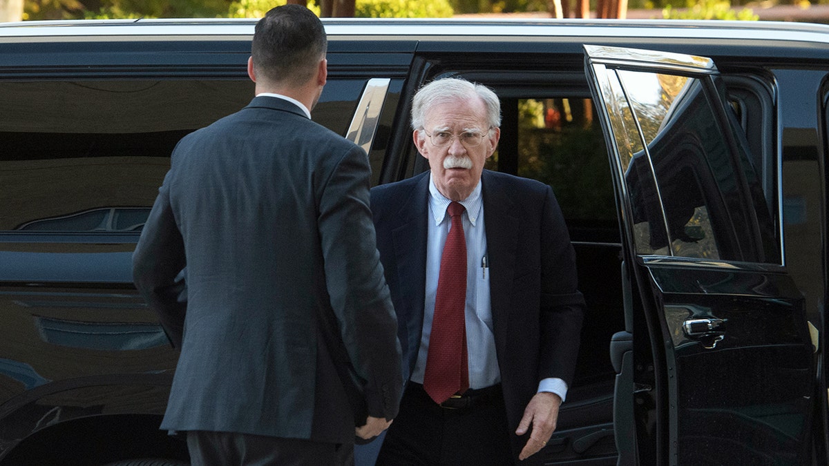 John Bolton exits vehicle as he arrives at court.