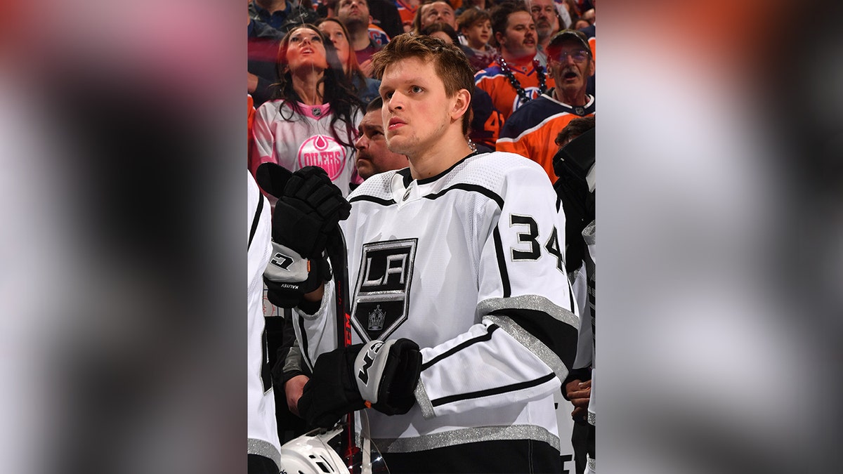 Arthur Kaliyev in white and black jersey during hockey match