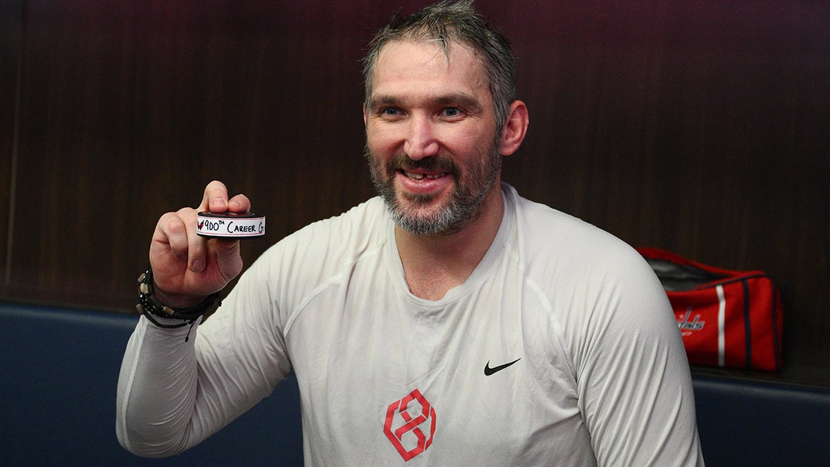 Alex Ovechkin poses with the puck after his 900th goal of his career