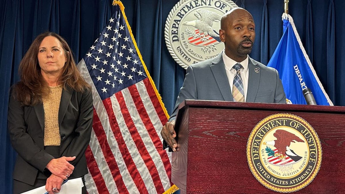 Ted Docks and U.S. Attorney Leah Foley speak at a Department of Justice news conference in Boston.