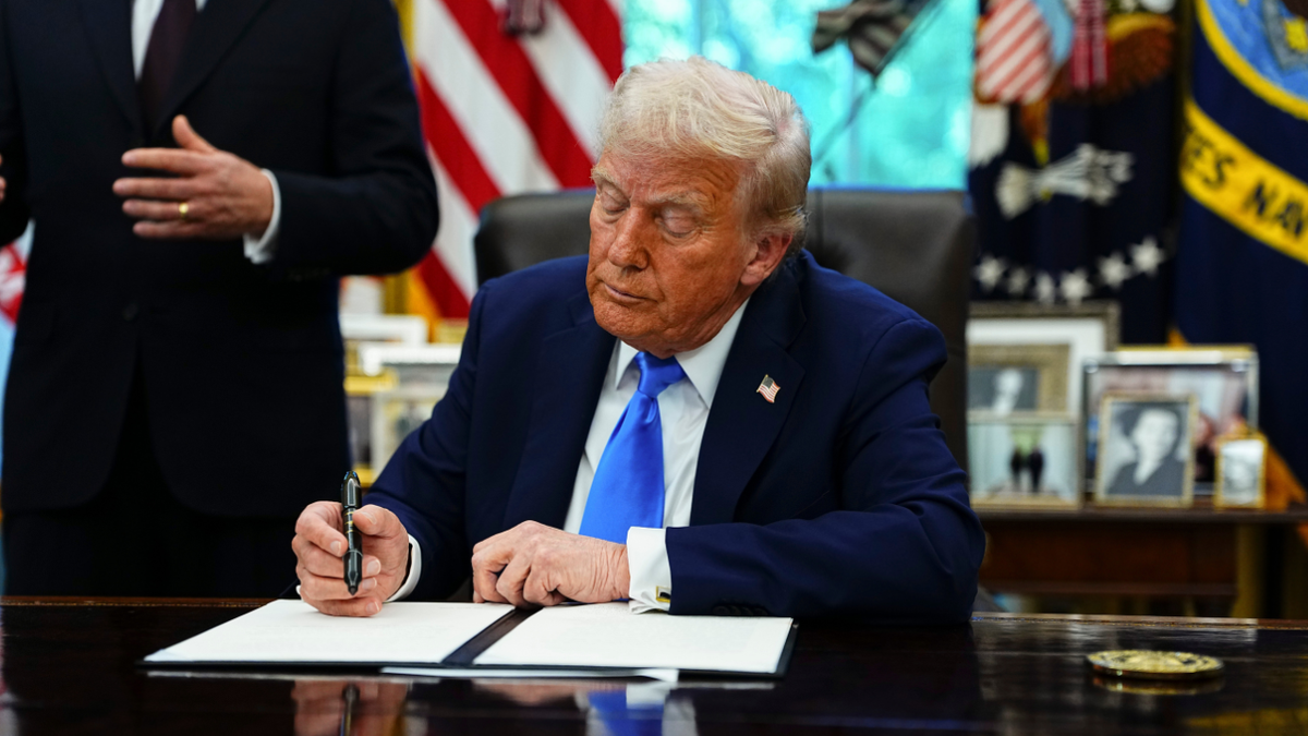 President Donald Trump signs the H-1B executive order at the White House.