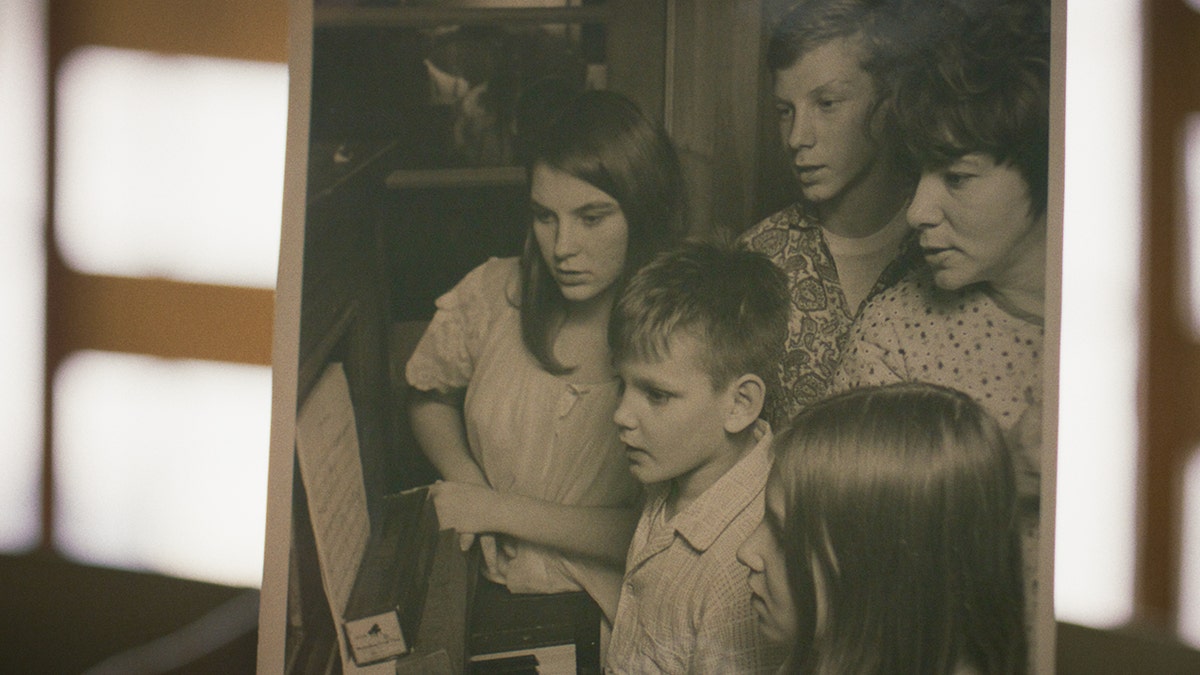 Family photo of the Carrol children, Jean, Steve, Pat, and Mike sitting with Dorothy at the piano.