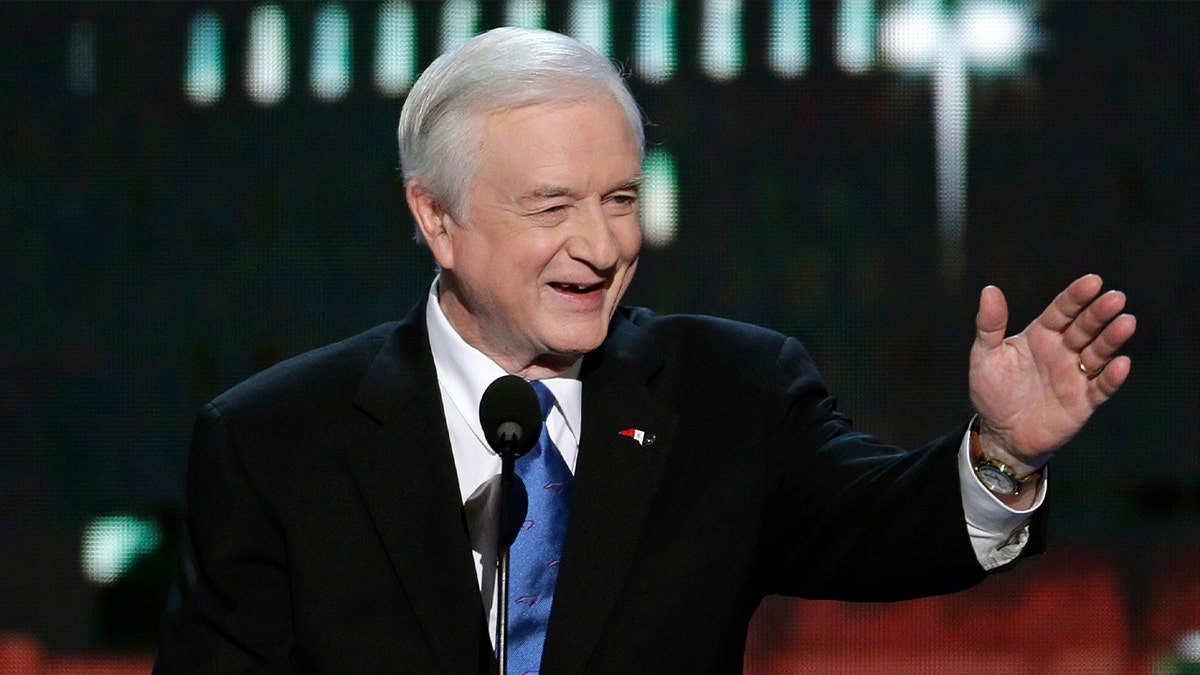 jim hunt in suit smiling and waving