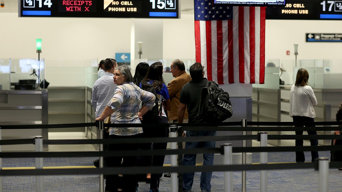 Travelers stand in line to speak to CBP officers after arriving at Miami airport