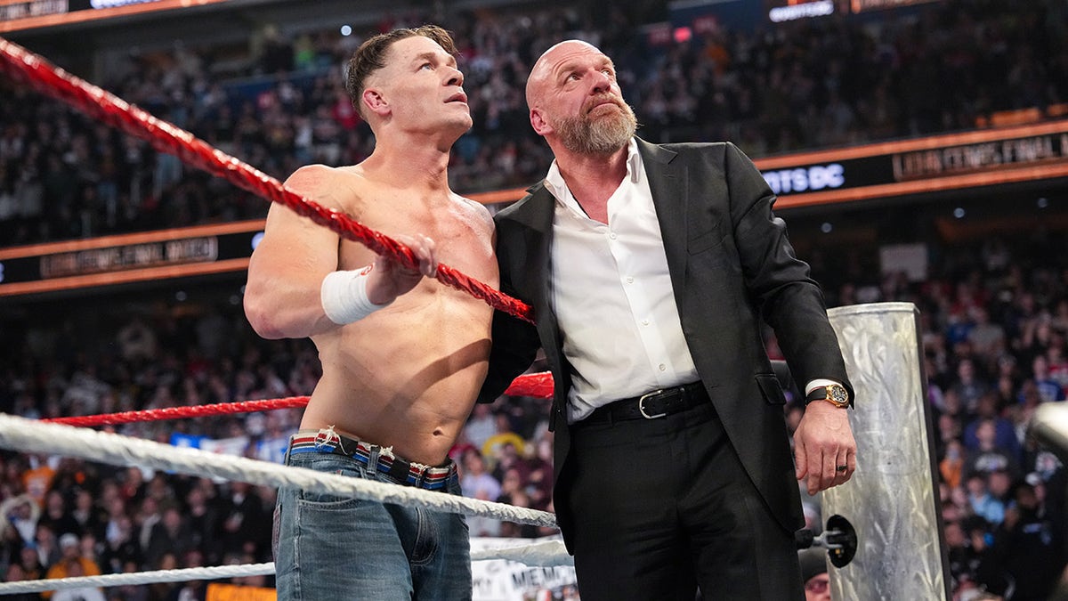 John Cena and Triple H look at the sceen