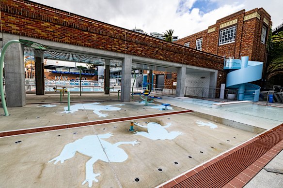 The children’s water play area includes a splash pad and water spray feature beneath the pool’s heritage sundeck.