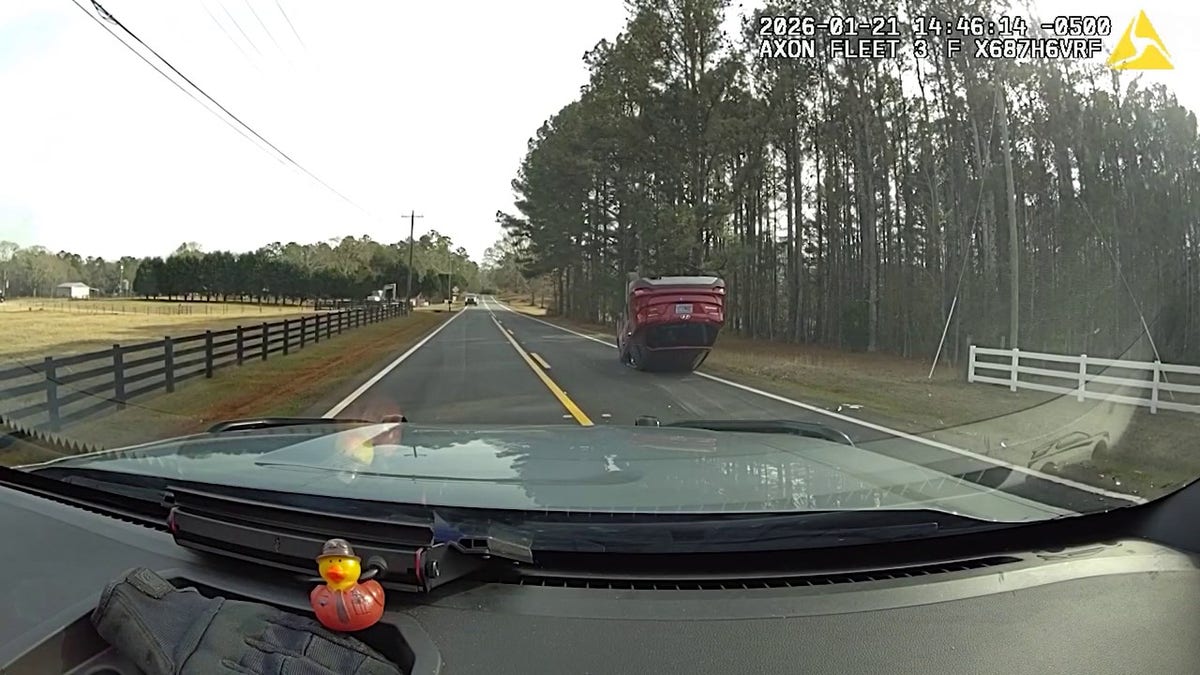Red SUV pictured from dash-camera footage following roll-over crash
