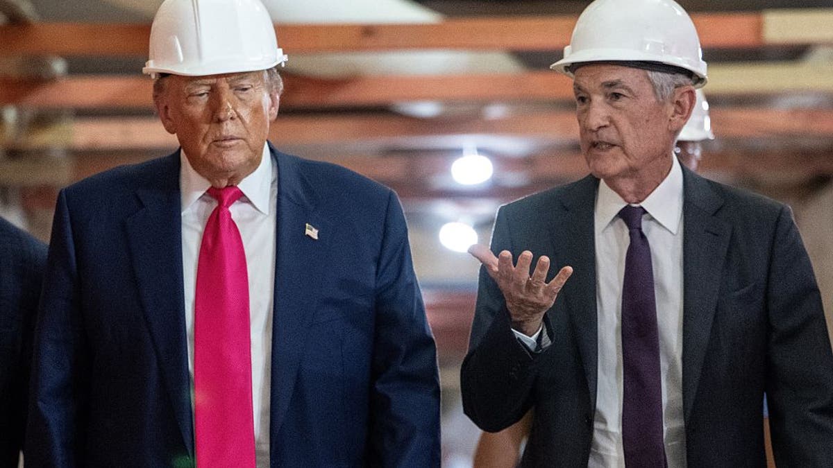President Donald Trump speaks with Federal Reserve chair Jerome Powell (R) as he visits the Federal Reserve in Washington, D.C., on July 24, 2025. 