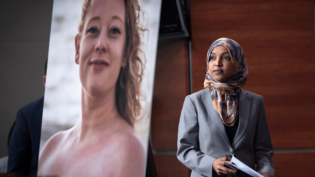Representative Ilhan Omar (D-MN) with a photo of Renee Good