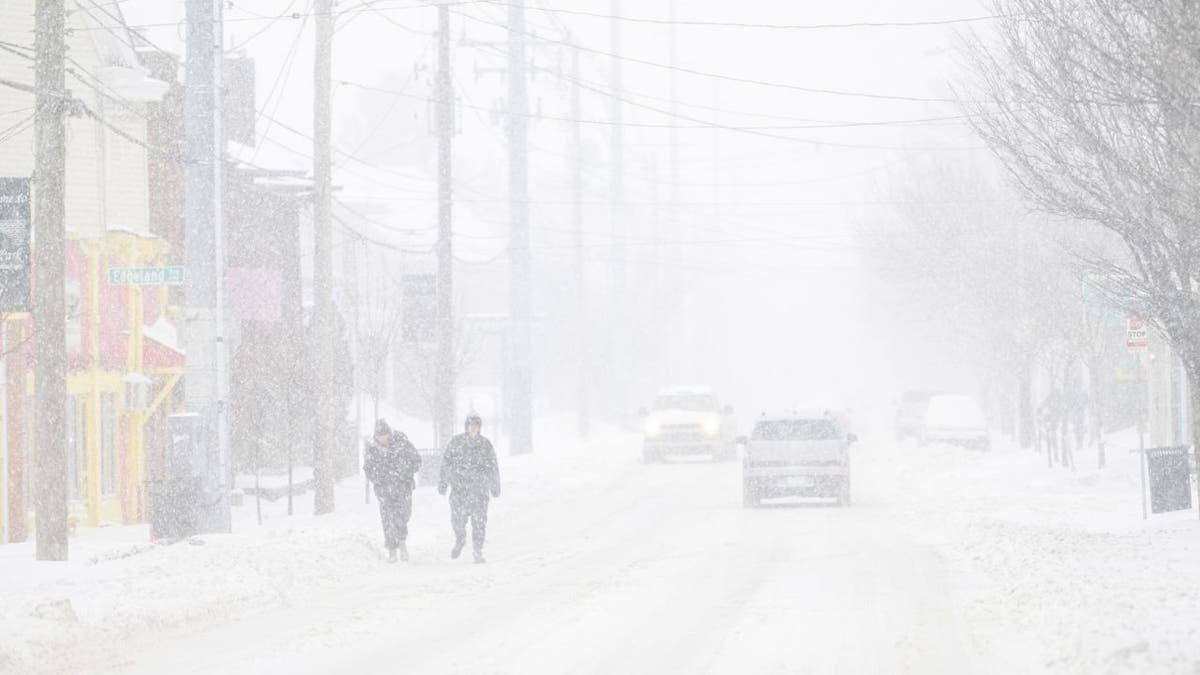 People walking through heavy snow during a winter storm in Kentucky