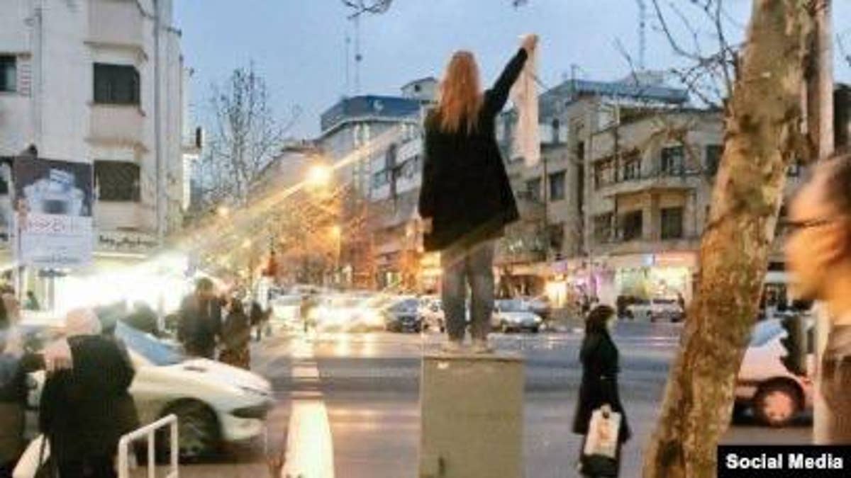 Maryam Shariatmadari is detained by Iranian security forces after removing her hijab in protest against mandatory veiling laws during the "Girls of Revolution Street" demonstrations in Tehran. Shariatmadari was later sentenced to one year in prison for what authorities described as "encouraging corruption by removing her hijab."