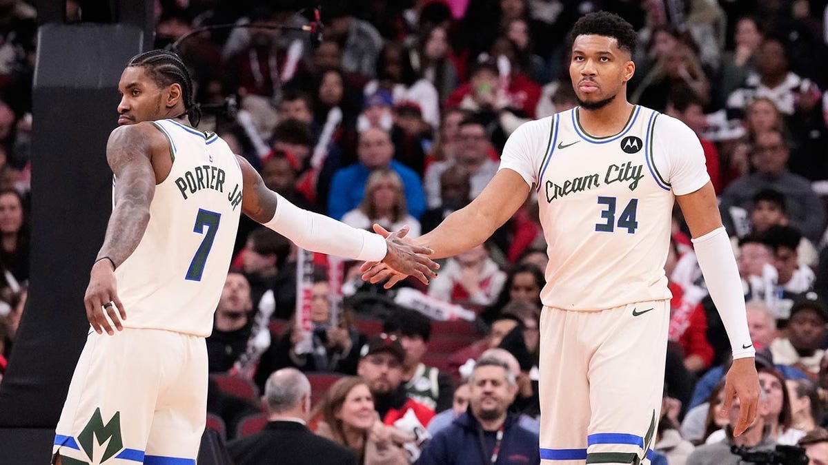 Giannis Antetokounmpo shakes hands with teammate