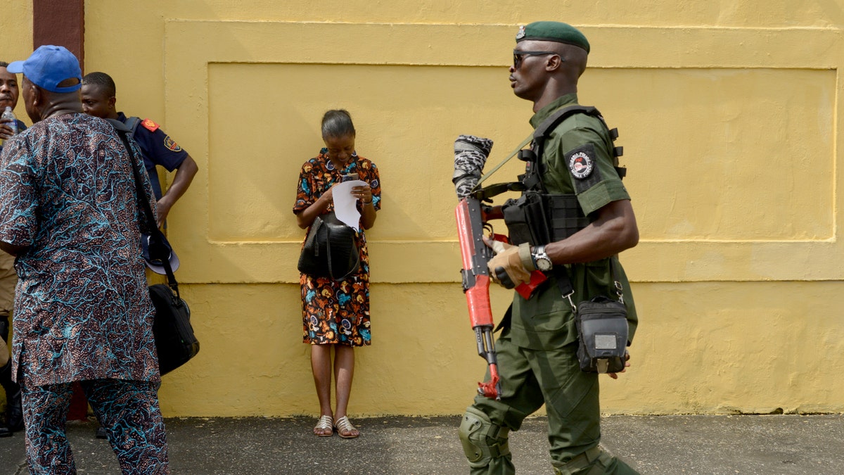 Police officer moves through a crowd gathered on a city street during a public demonstration.