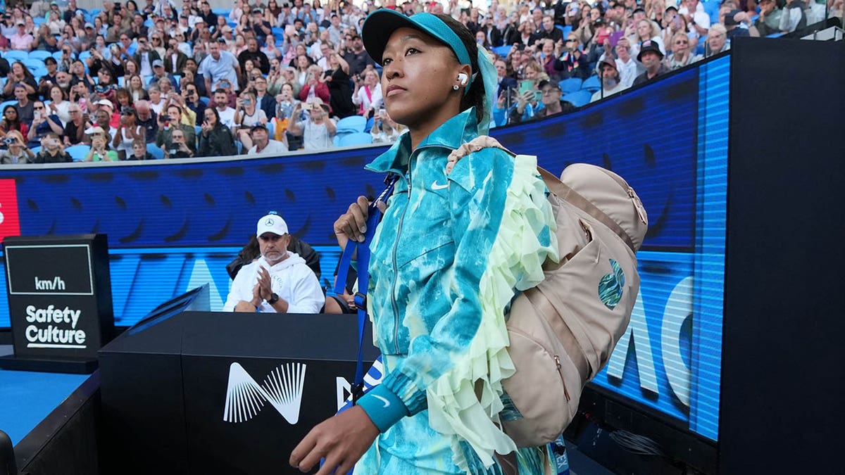 Naomi Osaka walks onto the court