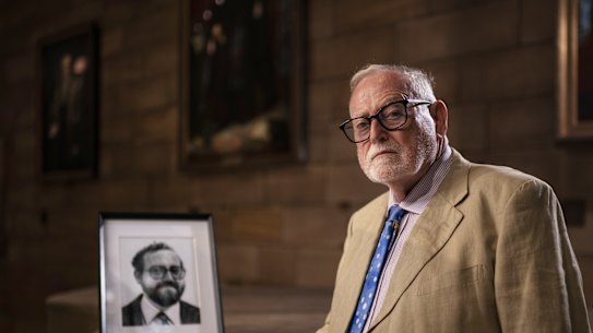 Ross Gittins in the Great Hall of Sydney University, with a portrait of himself taken in 1982.